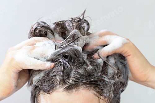 Preview: A girl washes her hair with shampoo on white background, front view