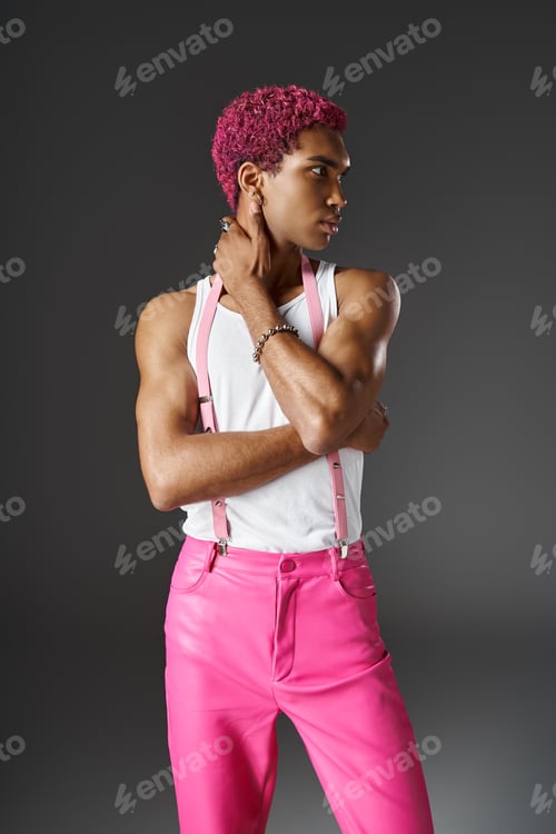 Preview: good looking man in pink pants with suspenders with crossed hands looking away, fashion and style
