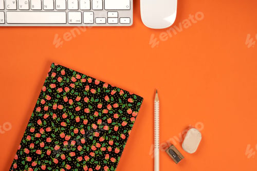 Preview: Above orange office desk with, notebook, computer keyboard and mouse
