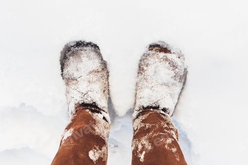 Preview: Brown boots covered with snow in the winter