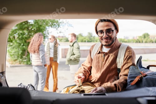 Preview: Arabian guy putting clothes into trunk