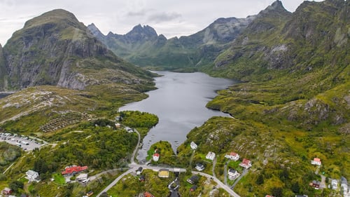Preview: Aerial view of a scenic fjord surrounded by green mountains and quaint houses in Lofoten, Norway