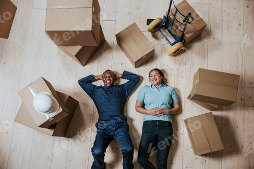 Preview: Happy moving service staff lying on the floor