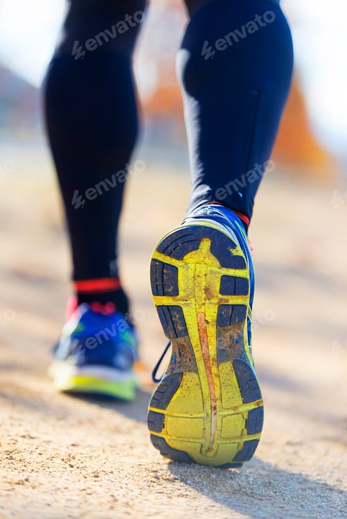 Preview: Athlete runner feet running in nature, closeup on shoe.