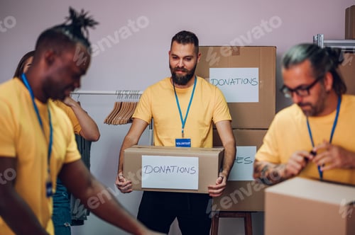 Preview: Group of multiracial volunteers working in community charity donation center