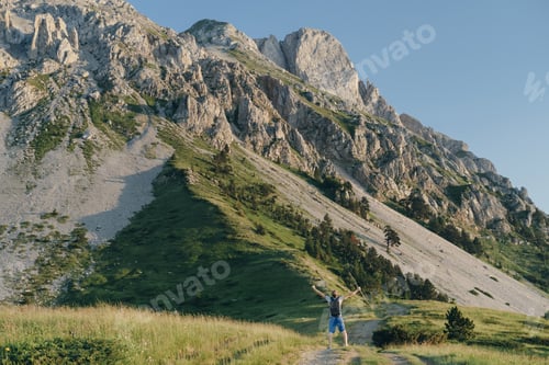 Preview: Man traveler raised his hands up against the background of the mountain, Montenegro, copy space