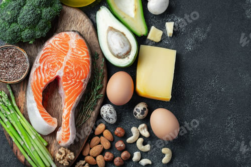 Preview: A set of healthy food for keto diet on a dark background. Fresh raw salmon steak with flax seeds