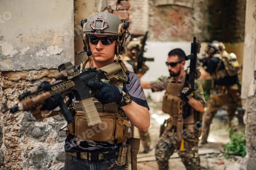 Preview: Group of air soft players with weapon attacking opponent in ruins.
