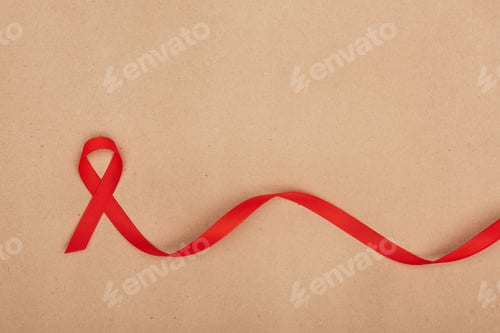 Preview: top view of red aids ribbon, isolated on beige