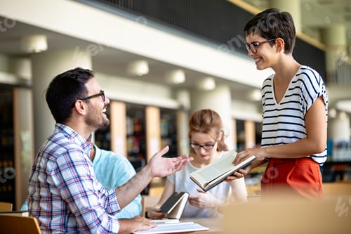 Preview: Happy group of success students studying and working together in a college library