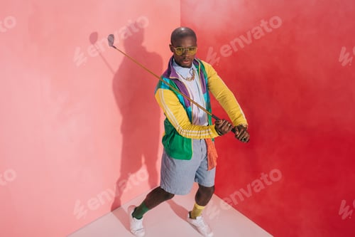 Preview: high angle view of stylish african american man playing golf in studio