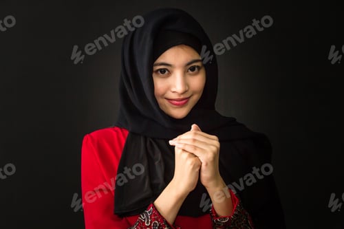 Preview: Portrait of beautiful young muslim woman on a black background.