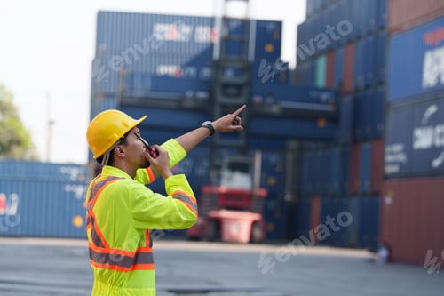 Preview: Worker directs cargo operations at shipping yard in bright daylight