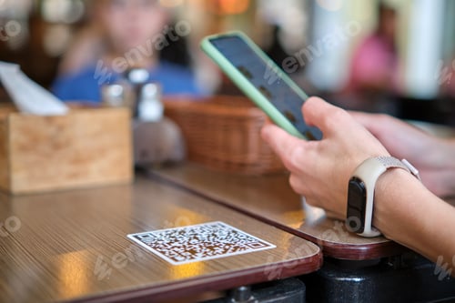 Preview: Closeup of guest hand ordering meal in restaurant while scanning qr code
