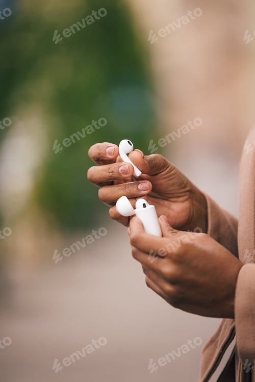 Preview: Close up of a woman opening her earphones box, using it.