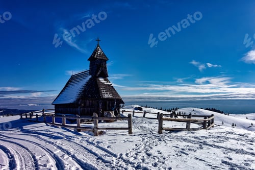 Preview: a very tall wooden church in the middle of snow covered ground