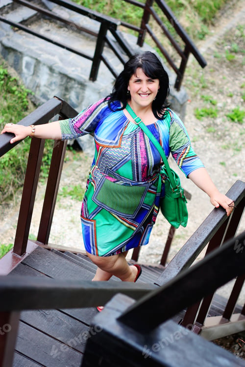 Preview: Beautiful curve plus size woman looking up and smiling.