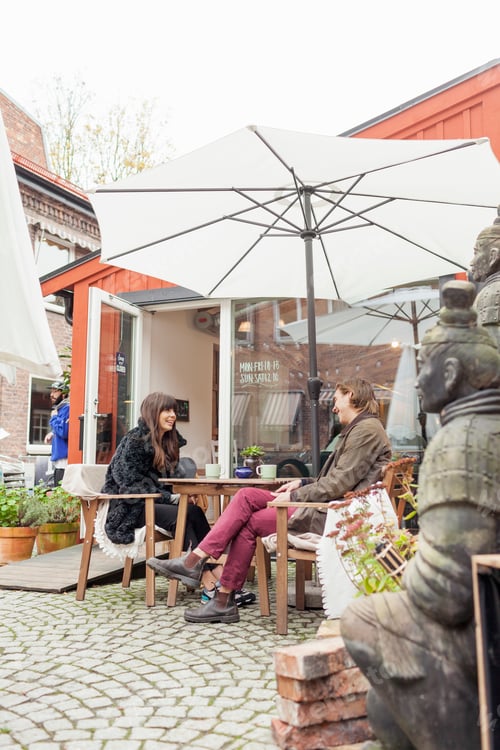 Preview: Happy young couple having coffee at cafe backyard