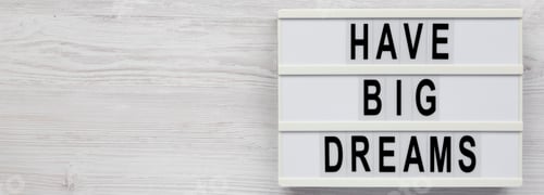 Preview: 'Have Big Dreams' on a lightbox on a white wooden surface, overhead view. Flat lay, top view