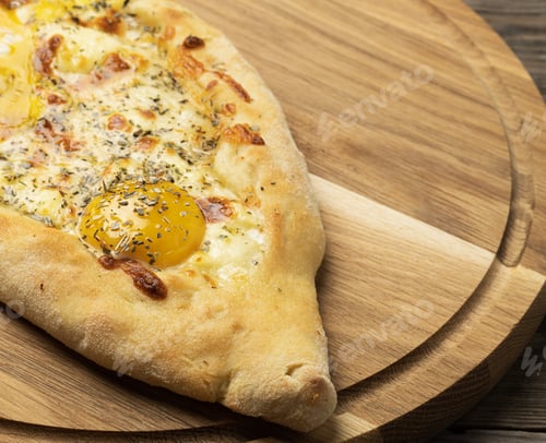 Preview: Baked adjarian khachapuri with whole egg yolk on wooden board