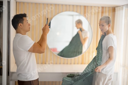 Preview: Man take picture on smartphone of girl with dress
