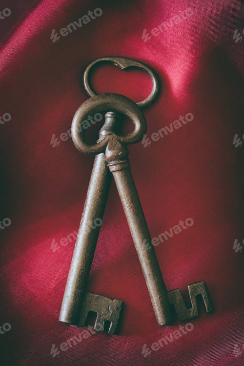 Preview: Old medieval wrought iron keys on red background