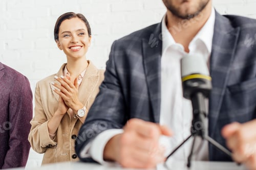 Preview: selective focus of attractive businesswoman in formal wear clapping in conference hall