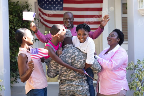 Preview: African american soldier father greeting his smiling three generation family in front of the house