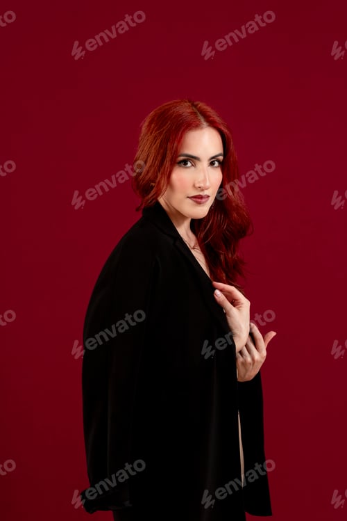 Preview: Elegant woman looking at the camera while posing against a colored background.