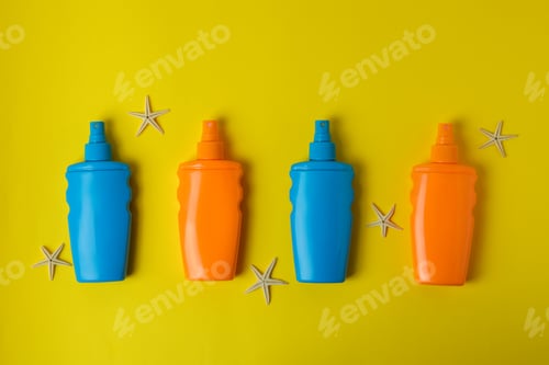Preview: Bottles of sunscreen and starfishes on yellow background