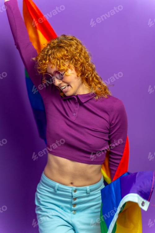Preview: Lesbian young woman raising lgbt rainbow flag