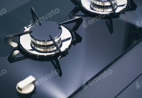 Preview: closeup of expensive black gas stove with glass and metal finish