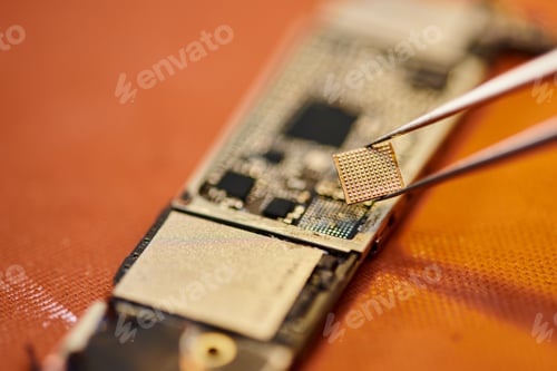 Preview: close up view of tweezers with electronic chip near microscheme in workshop, phone repair business
