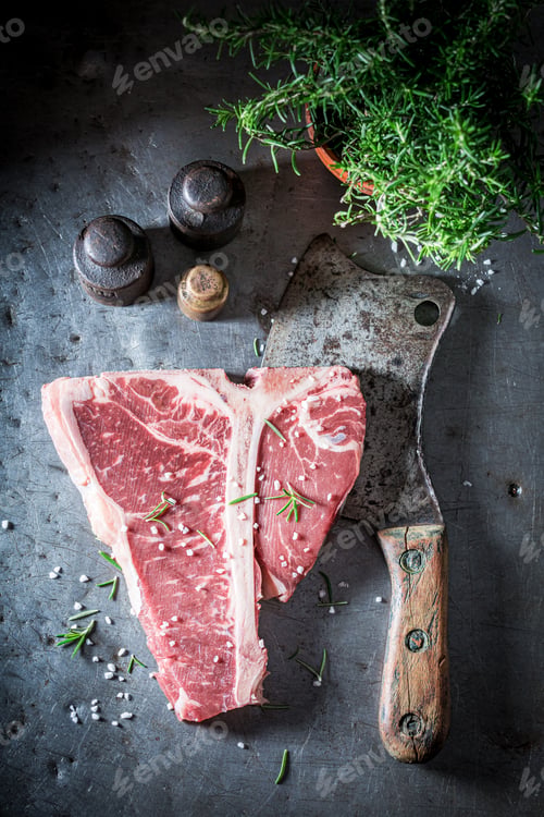 Preview: Raw steak for roasted. Bloody steak with salt and rosemary.
