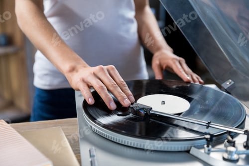 Preview: Cropped, close-up image of woman using vinyl audio player