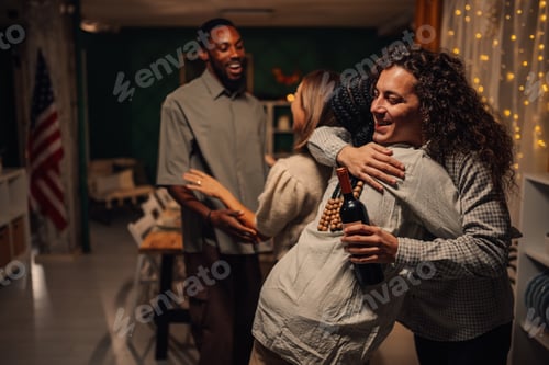 Preview: Friends embracing at thanksgiving dinner party, celebrating with wine and warmth