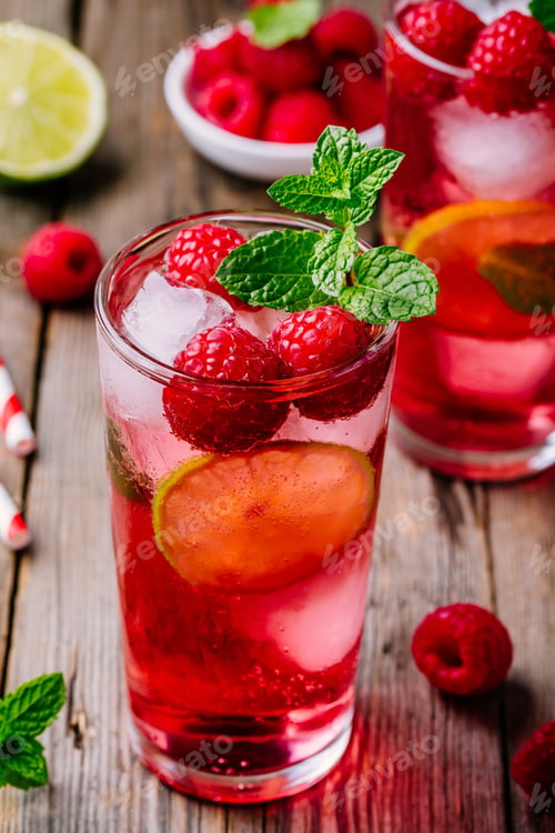 Preview: Raspberry Mojito Lemonade with lime and fresh mint in glass on wooden background