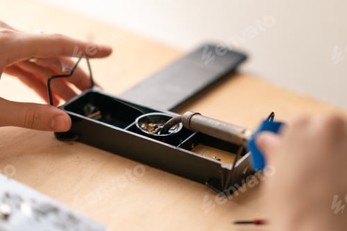 Preview: young man dipped a soldering iron into rosin