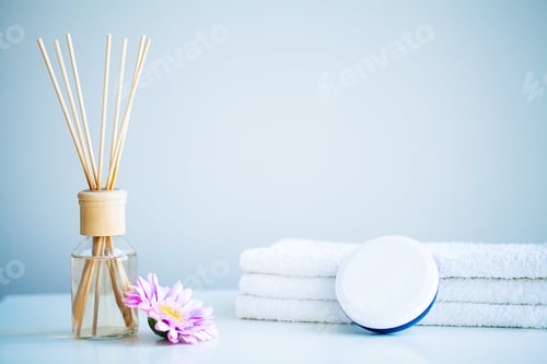 Preview: Spa concept. Moisturizing cream, towels and aroma oil on table in bath room