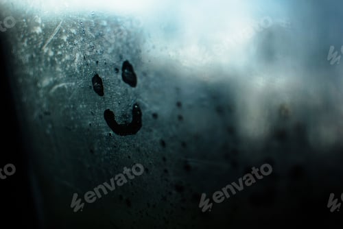 Preview: Closeup shot of a smiley face drawn on the steamed glass