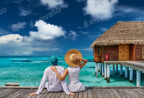 Preview: Couple in white on a tropical beach jetty