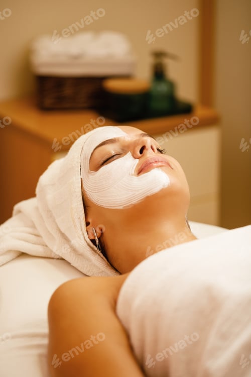 Preview: Beautiful woman with facial mask relaxing at the spa.