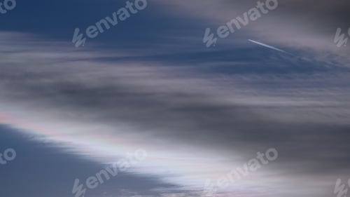 Preview: Colorful Clouds At Sunset Against A Blue Sky. Clouds Have Iridescence (Irisation) On The Edges With
