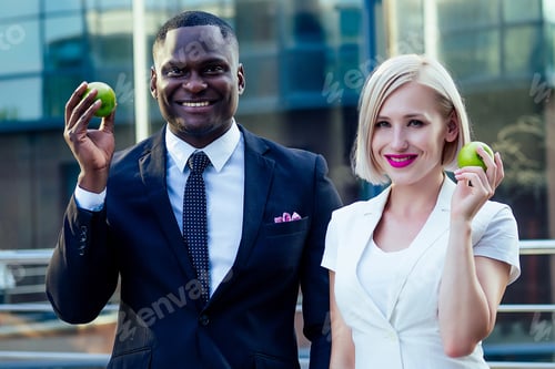 Preview: handsome Afro businessman in a stylish black suit with attractive blonde business lady