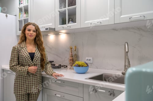 Preview: Woman in Stylish Suit Poses in Modern Kitchen