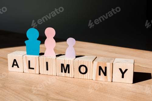Preview: wooden blocks with alimony lettering near family paper people on black