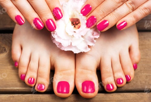 Preview: Pink manicure and pedicure with flower close-up, isolated on a wooden background, top view