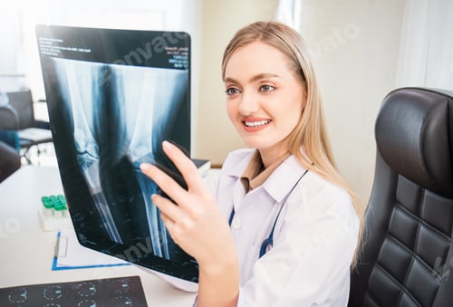 Preview: Portrait of caucasian blonde woman doctor holding and analyze x-ray in medical office