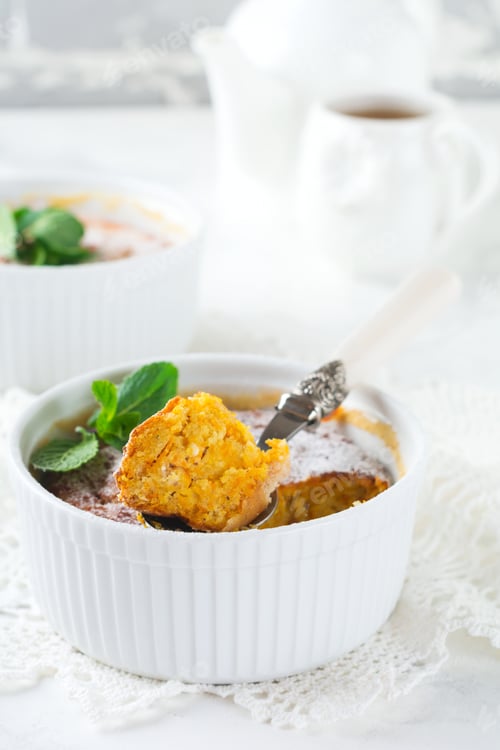 Preview: Cheese Casserole with pumpkin and cinnamon for breakfast in a white ceramic form on a light backgrou