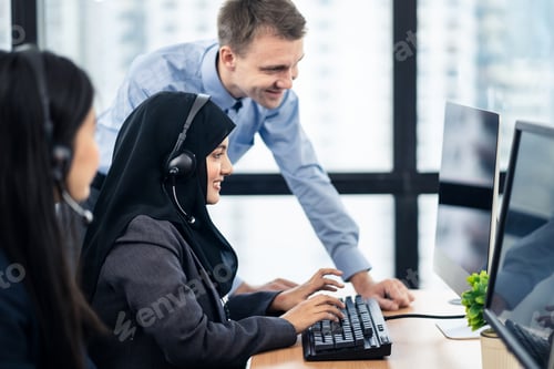 Preview: Call center Asian Muslim girl typing on keyboard having some advice from colleague